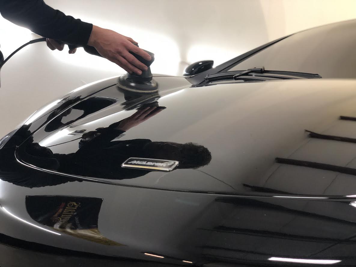 Man working on paint correction on car.